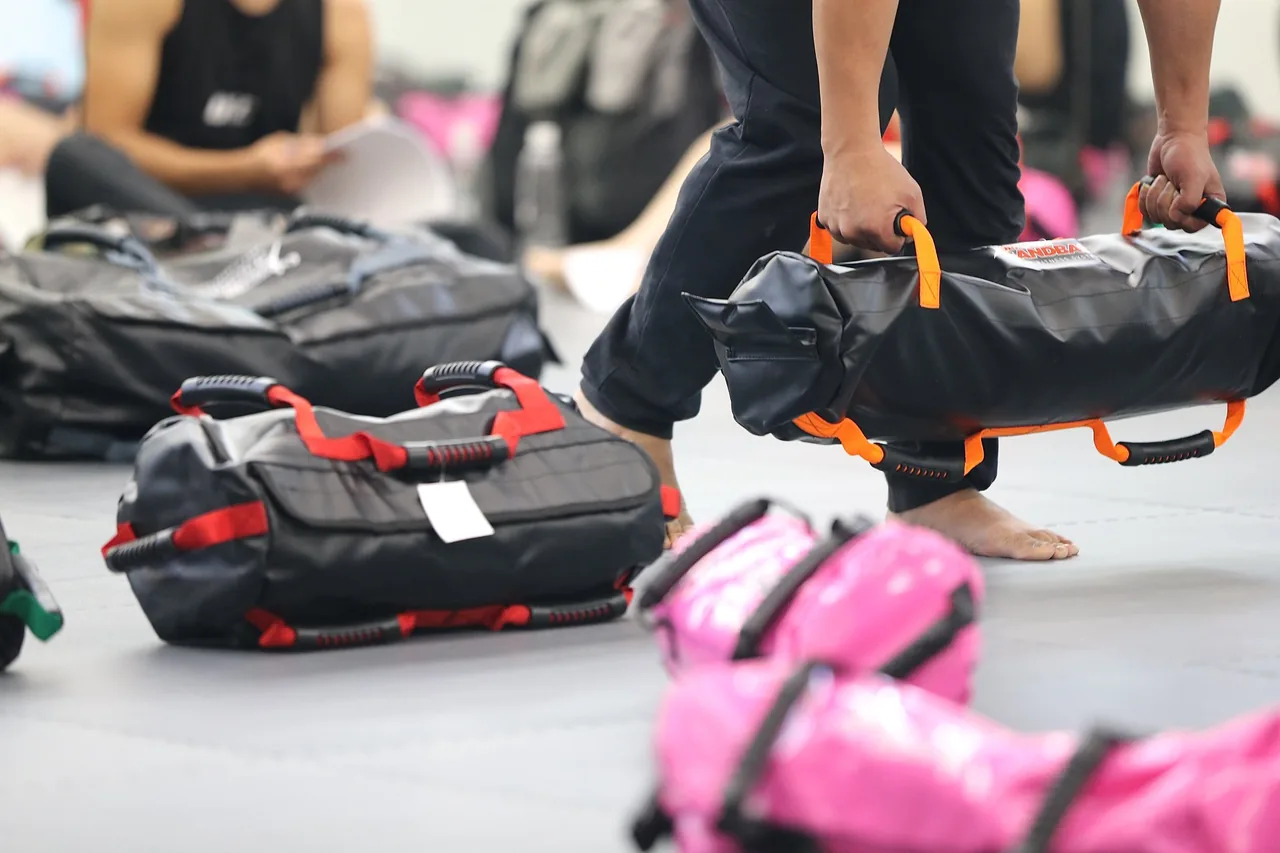 An athlete using the outside handles of an Ultimate Sandbag