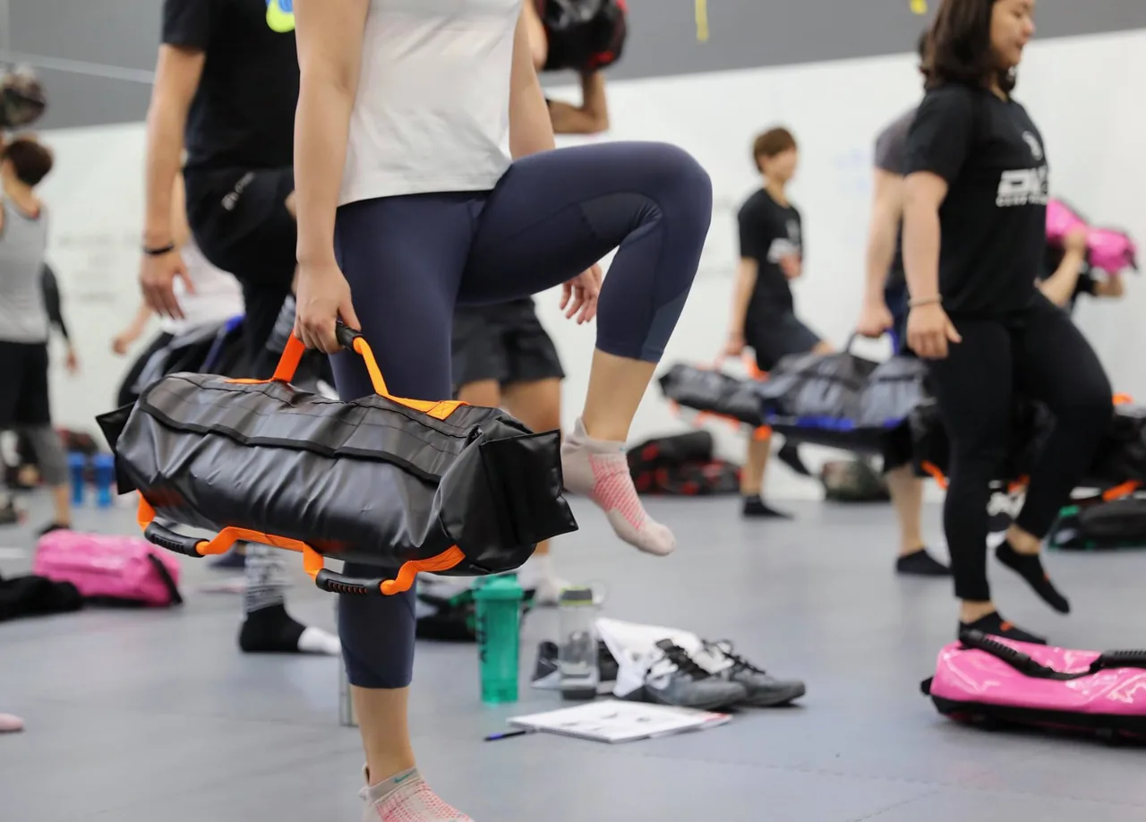 An athlete learning a step-up drill with an Ultimate Sandbag